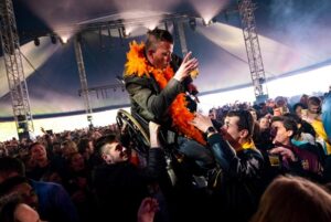 Rolstoelrijder wordt opgetild op festival in menigte